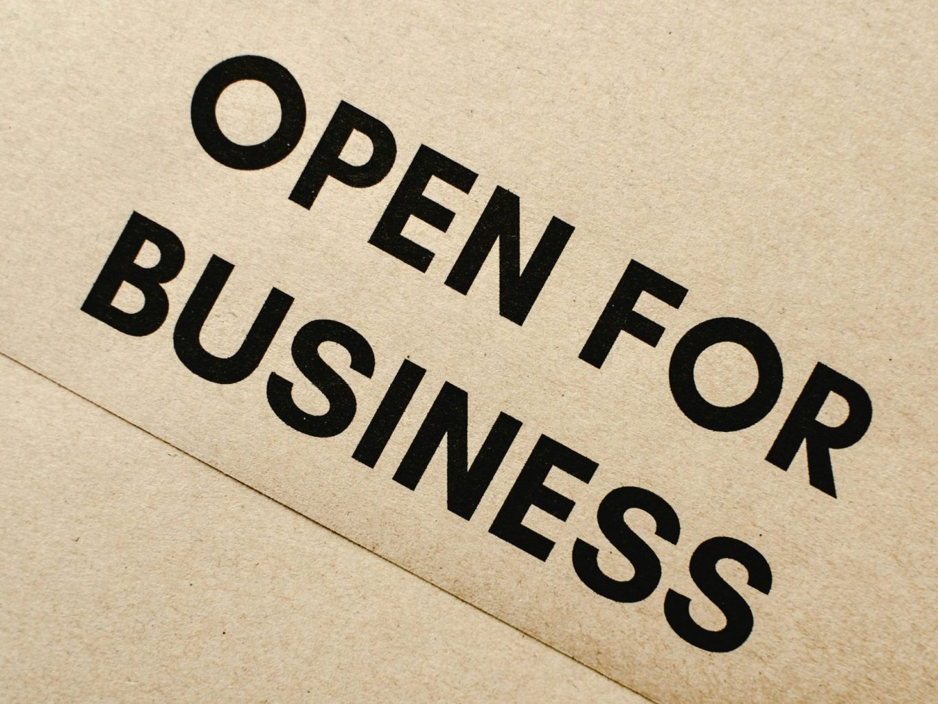 Texte en noir sur fond beige : "OPEN FOR BUSINESS".